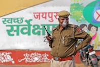 Police personnel wear protective masks in wake of the deadly novel coronavirus at a railway station in Jaipur.