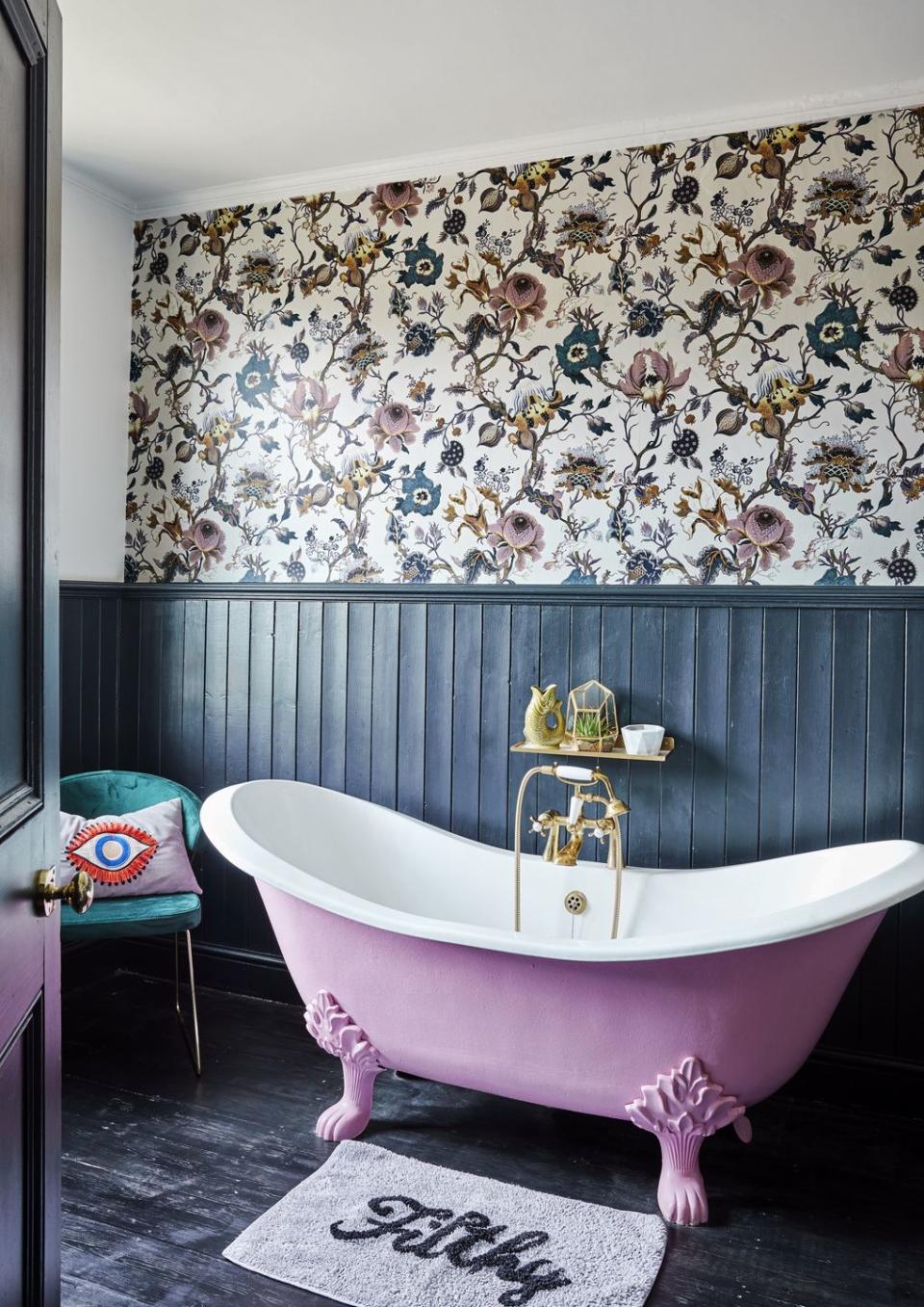 colourful bathroom with floral wallpaper and pink bath tub