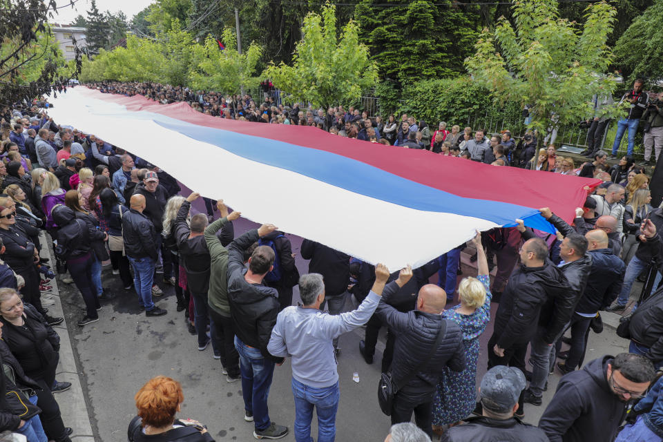 People hold a giant Serbian flag during a protest in front of the city hall in the town of Zvecan, northern Kosovo, Wednesday, May 31, 2023. Hundreds of ethnic Serbs began gathering in front of the city hall in their repeated efforts to take over the offices of one of the municipalities where ethnic Albanian mayors took up their posts last week. (AP Photo/Bojan Slavkovic)