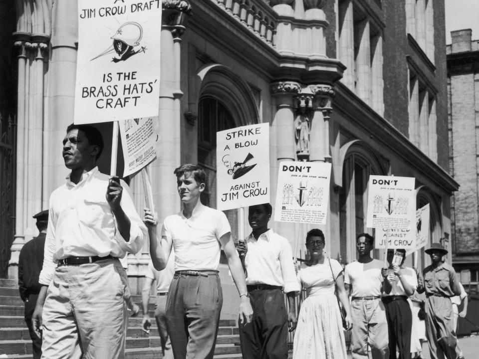 Civil rights activist Bayard Rustin (1912 – 1987) leads other members of the 'Campaign to Resist Military Segregation' picketing registration for America's postwar draft at Haaron High School, New York City, 30th August 1948. They are protesting against the 'Jim Crow' draft, a reference to the so-called Jim Crow Laws enforcing racial segregation.