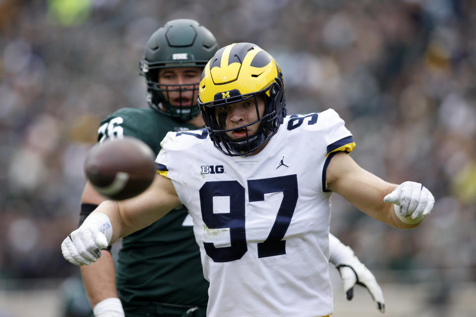 Michigan's Aidan Hutchinson (97) eyes a loose ball in front of Michigan State's AJ Arcuri during the second quarter of an NCAA college football game, Saturday, Oct. 30, 2021, in East Lansing, Mich. Hutchinson recovered the ball in the end zone for an apparent touchdown until the Michigan State runner was ruled down. (AP Photo/Al Goldis)