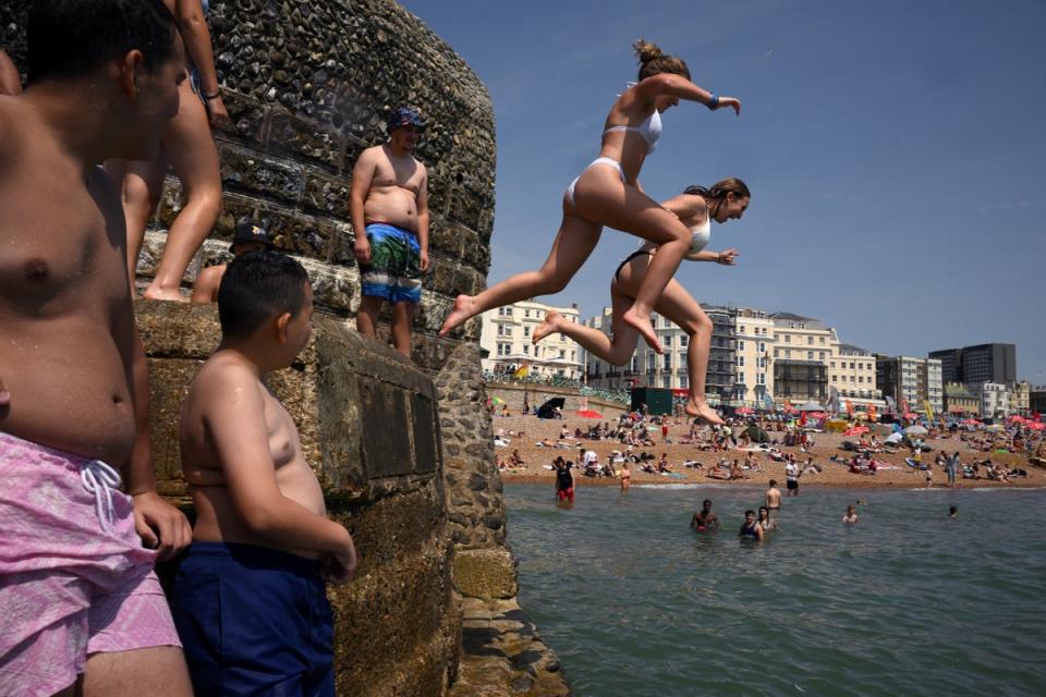 People jump into the sea at Brighton, (AFP via Getty Images)