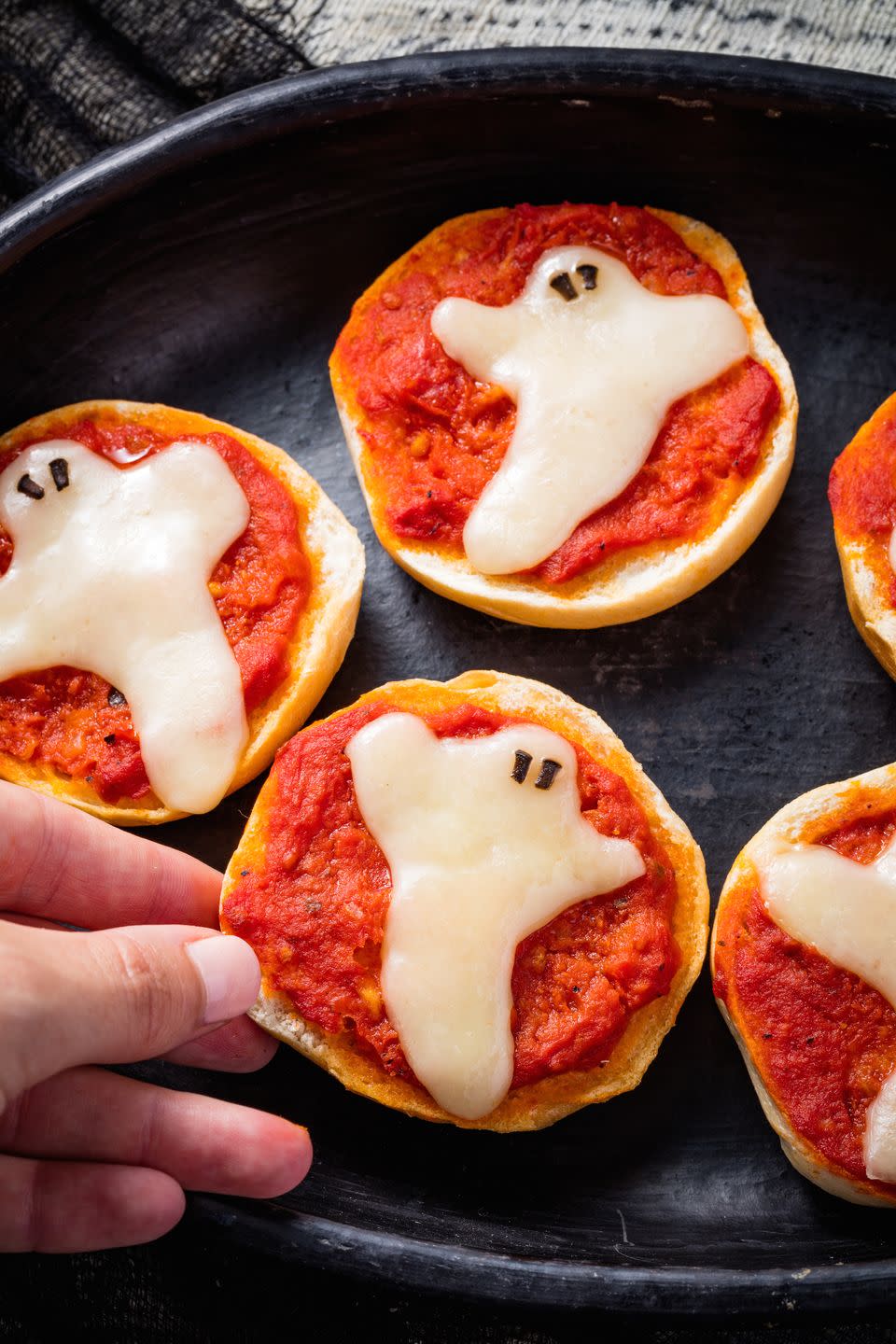 <p>The scariest thing about these pizza bagels is how fast we're going to eat them.</p><p>Get the recipe from <a href="https://www.delish.com/holiday-recipes/halloween/recipes/a49353/ghost-pizza-bagels-recipe/" rel="nofollow noopener" target="_blank" data-ylk="slk:Delish;elm:context_link;itc:0;sec:content-canvas" class="link ">Delish</a>.</p>