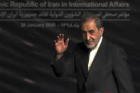 In this Jan. 30, 2020, photo, Ali Akbar Velayati, adviser to the Iranian supreme leader Ayatollah Ali Khamenei, waves to media at the conclusion of his press conference, in Tehran, Iran. In hard-hit Iran, state-run TV announced that Velayati was quarantined at home after testing positive for the virus. He is a close, trusted adviser to the 80-year-old leader of the Islamic Republic, who was recently seen wearing disposable gloves at a tree-planting ceremony, apparently out of caution about the virus. (AP Photo/Vahid Salemi)
