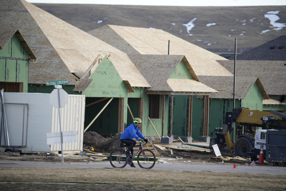 A cyclist passes by new homes under construction in a development wiped out by the Marshall Fire, Sunday, Feb. 5, 2023, in Superior, Colo. Authorities say they have wrapped up their investigation into what started the most destructive wildfire in Colorado history and will announce their findings on Thursday, June 8. (AP Photo/David Zalubowski)