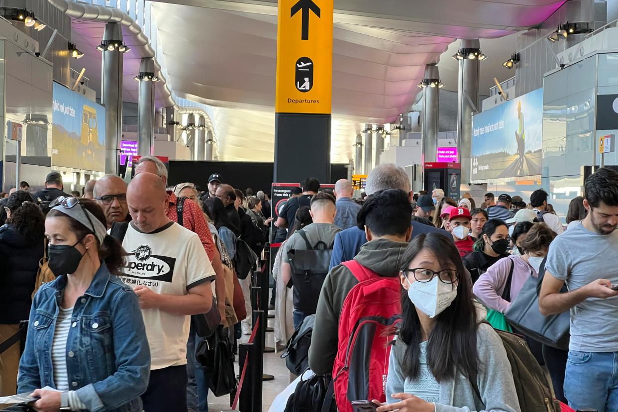 Travelers queue at security at Heathrow Airport in London, on June 22, 2022.