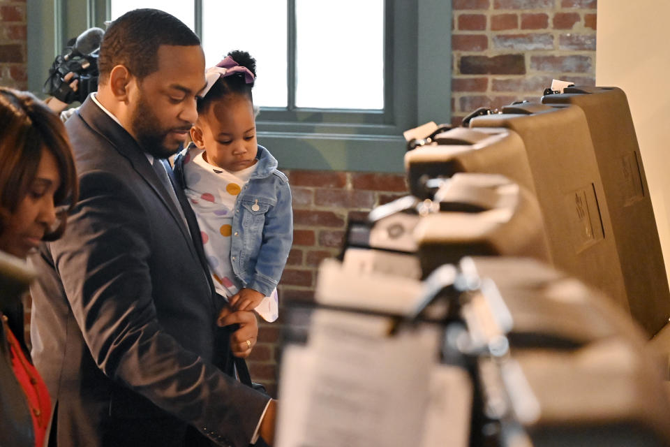 14-month-old Justice Booker looks on as her father, Kentucky Democratic candidate for Senate Charles Booker casts his early vote in the midterm election in Louisville, Ky., Thursday, Nov. 3, 2022. (AP Photo/Timothy D. Easley)