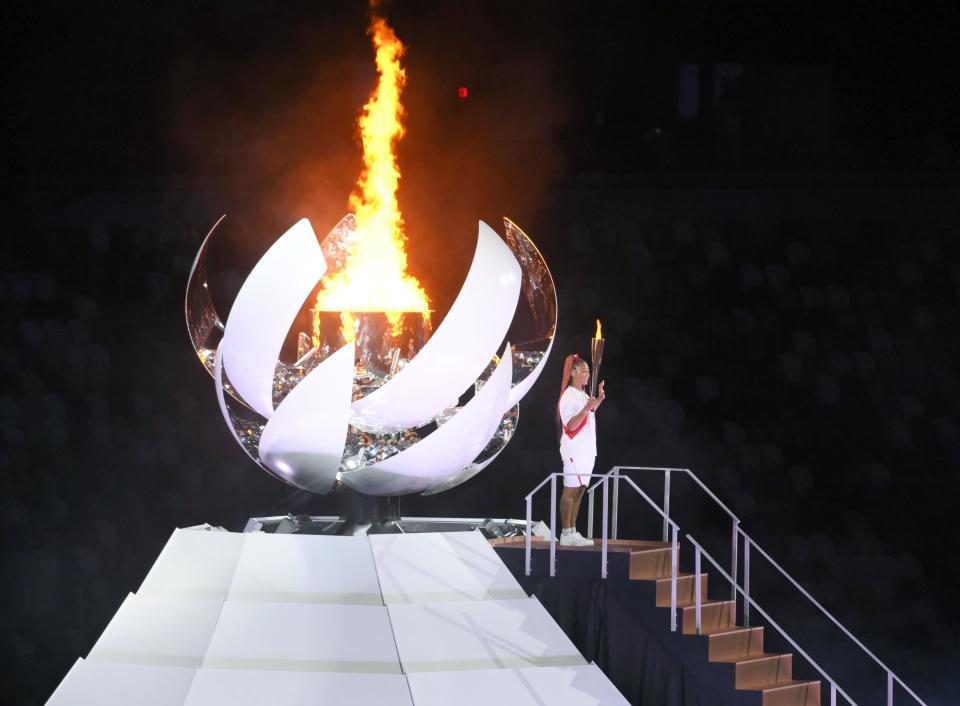 Naomi Osaka lights the Olympic flame during the Opening Ceremony in Tokyo (Picture: Reuters)