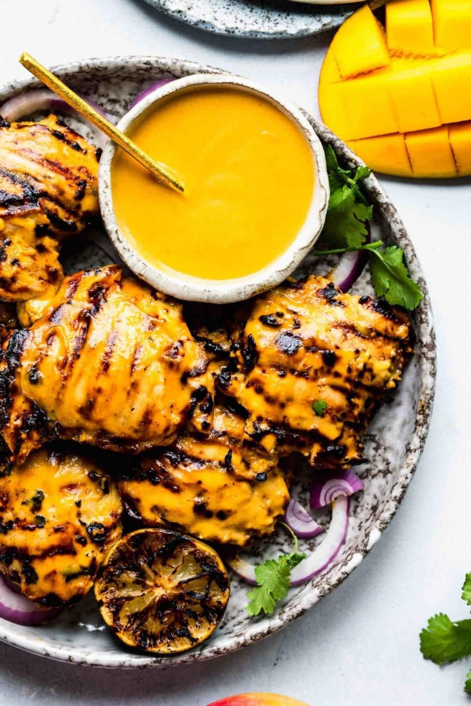 Mango chicken served on a plate with a side of mango sauce