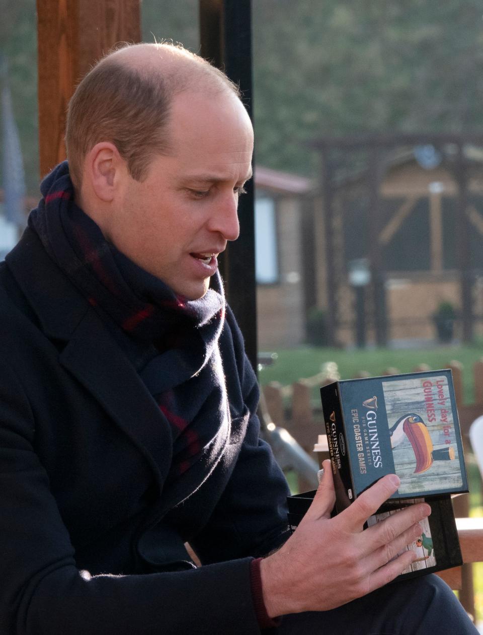 Britain's Prince William, Duke of Cambridge, receives a gift of a 'Guinnes Pub Game' during a visit to Cardiff Castle in Cardiff in south Wales, on December 8, 2020, on the final day of his engagements with Britain's Catherine, Duchess of Cambridge on their tour of the UK. - During their trip, their Royal Highnesses hope to pay tribute to individuals, organisations and initiatives across the country that have gone above and beyond to support their local communities this year. (Photo by Jonathan Buckmaster / POOL / AFP) (Photo by JONATHAN BUCKMASTER/POOL/AFP via Getty Images)