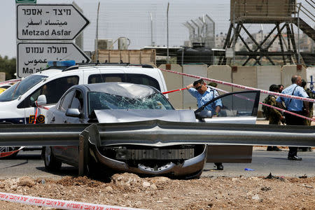 ?An Israeli police officer inspects the scene of a ramming and stabbing attack at Tekoa checkpoint near the West Bank city of Bethlehem July 10, 2017. REUTERS/Mussa Qawasma