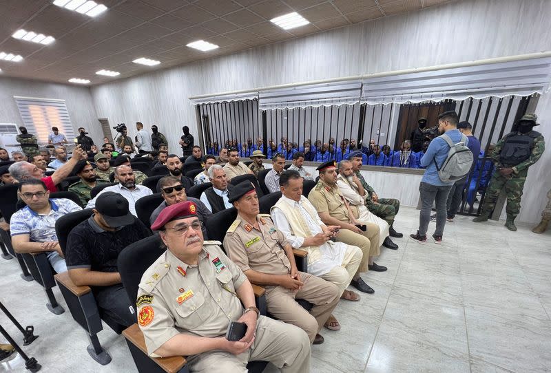 Suspects sit behind bars during a judgment sentence against 56 defendants accused of joining Islamic State group in the court in Misrata