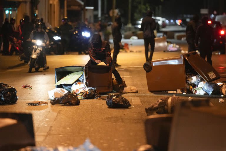 Manifestantes bloquean una calle con tachos de basura en Colombes, Francia, sábado 1 de julio de 2023. 