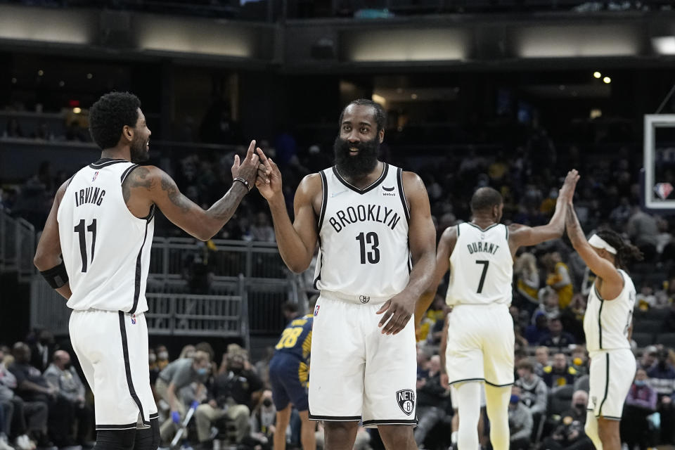 Brooklyn Nets' Kyrie Irving (11) and James Harden (13) celebrate during the second half of the team's NBA basketball game against the Indiana Pacers, Wednesday, Jan. 5, 2022, in Indianapolis. (AP Photo/Darron Cummings)