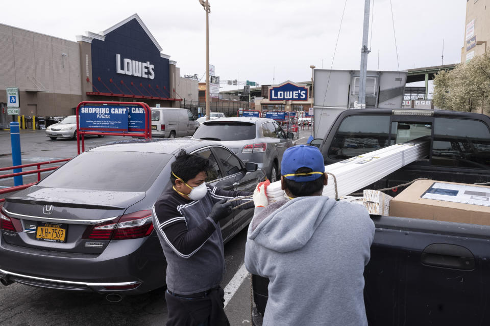 Lowe's customers wear masks as they load building supplies into their truck, Friday, April 3, 2020, during the coronavirus pandemic in New York. (AP Photo/Mark Lennihan)