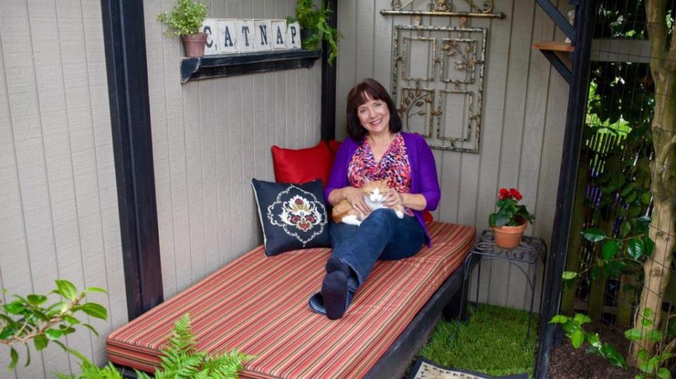 Cynthia Chomos and her cat Serena in Chomos's custom built "catnap catio."