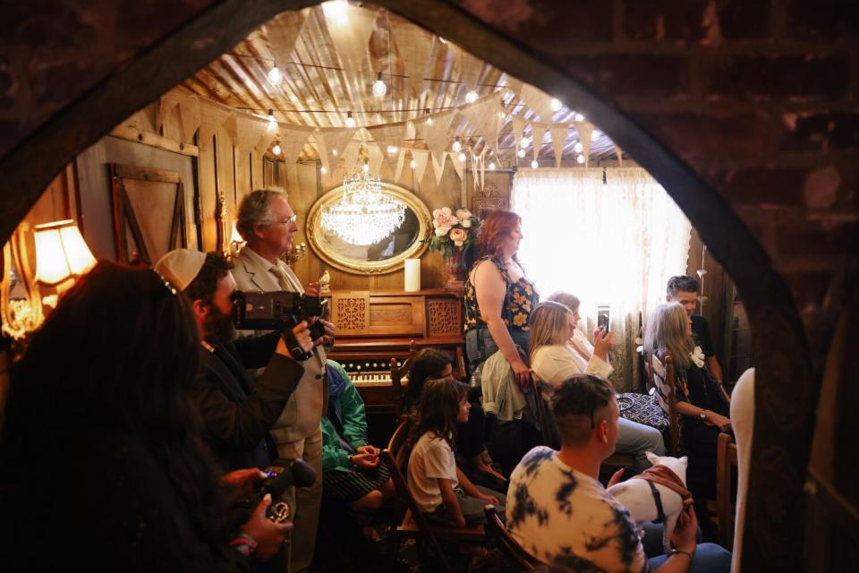 A crowd watches a wedding ceremony at the Old Brown House, an affordable wedding chapel.