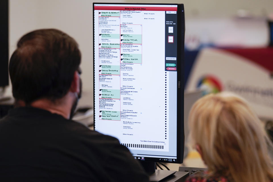 Officials work on ballots at the Gwinnett County Voter Registration and Elections Headquarters, Friday, Nov. 6, 2020, in Lawrenceville, near Atlanta. (AP Photo/John Bazemore)