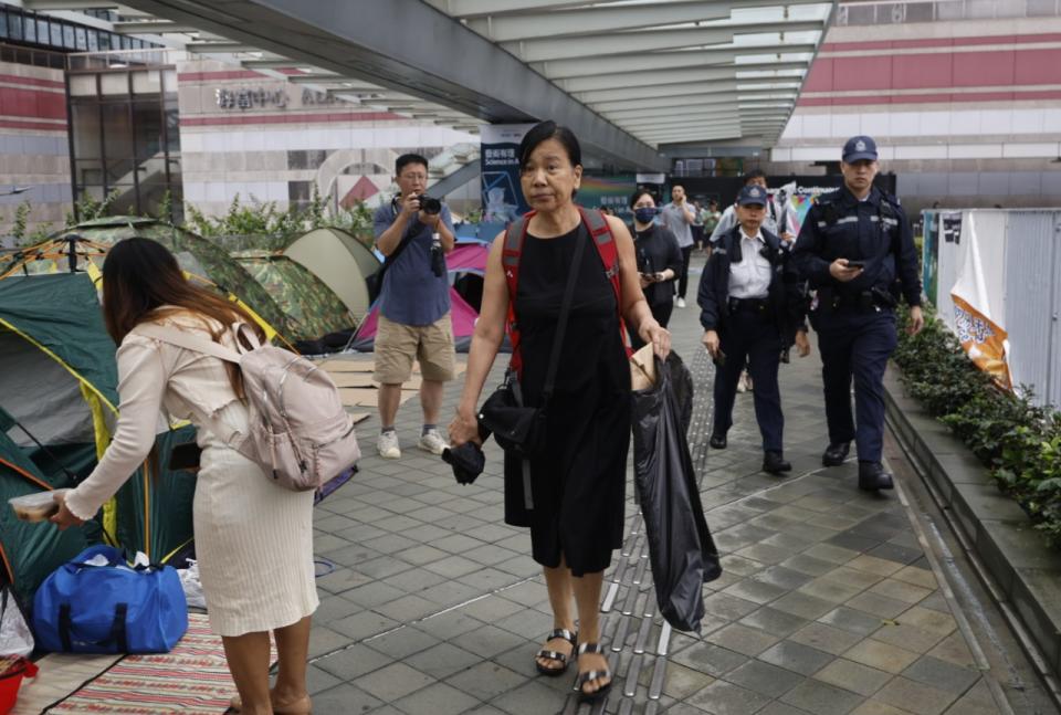 社民連主席陳寶瑩帶同道具到政府總部外示威，警員由地鐵站一路隨行。
