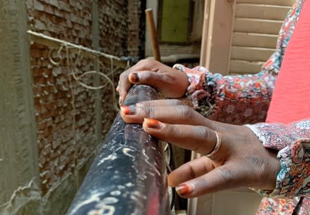 Female refugee who complained of violent sexual assault rests her hands on a balcony in Cairo