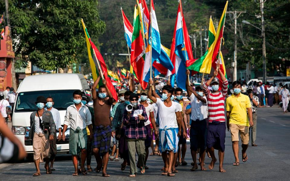 Military supporters carry Myanmar's national flags - SAI AUNG MAIN/AFP