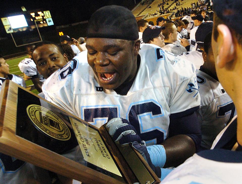 Hoggard's Jonathan Cooper moves in to kiss the Viking's 4-A state title trophy after defeating Mount Tabor 28-0 in Winston-Salem Saturday Dec. 8, 2007. Staff photo by Paul Stephen