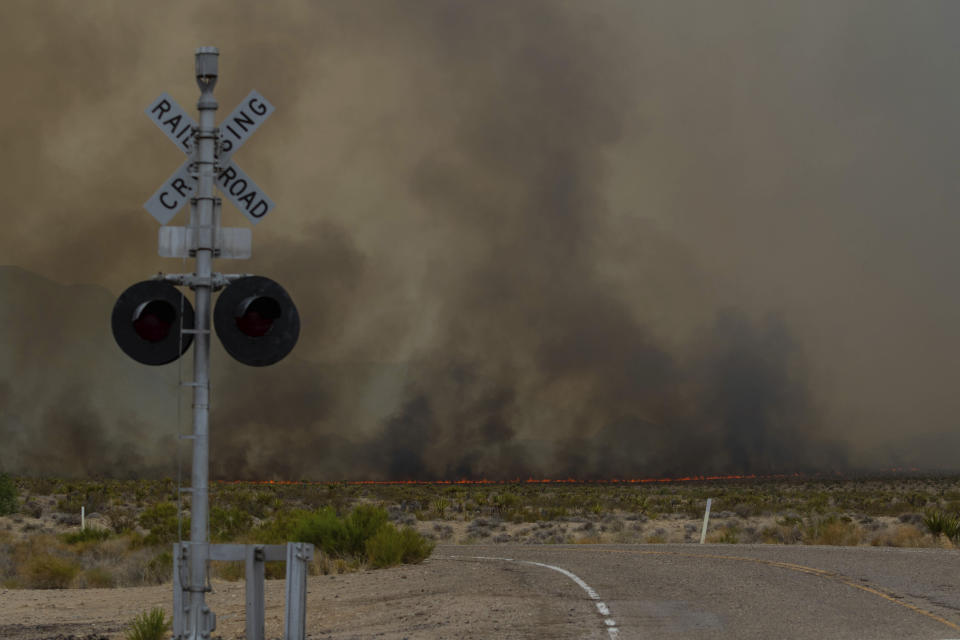 The York Fire burns towards a railway crossing on Sunday, July 30, 2023, in the Mojave National Preserve, Calif. (AP Photo/Ty O'Neil)