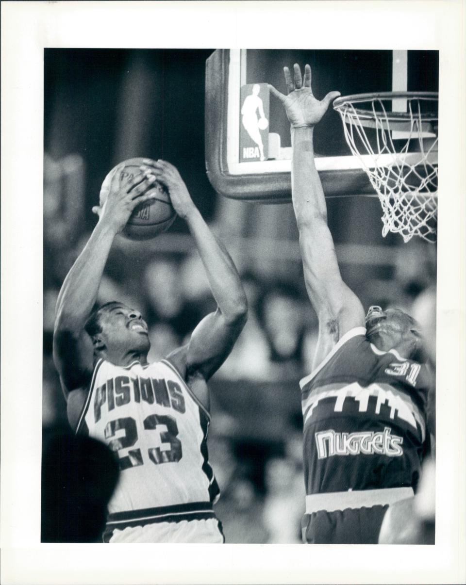 Pistons' Earl Cureton grabs a rebound away from Nuggets' Pete Williams ending the first half at the Pontiac Silverdome.