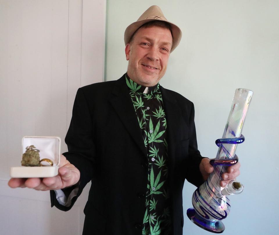 Bob Ellison holds a set of rings with a marijuana bud and a water pipe at his home in Cuyahoga Falls as he talks about Weeded Bliss, his marijuana-friendly wedding and event planning business.