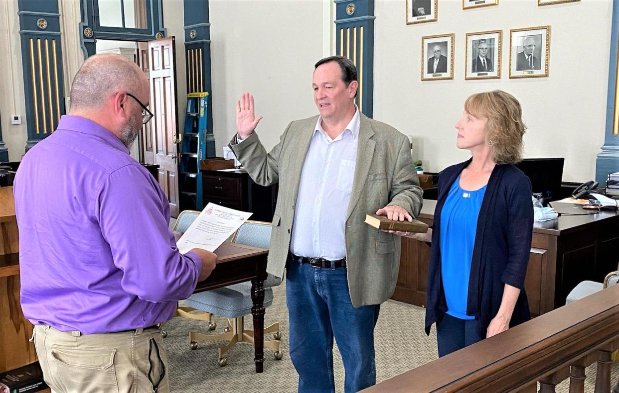 Holmes County Commissioner-elect Dave Hall was sworn in by Common Pleas Court Judge Sean Warner as County Recorder Anita Hall holds the Bible for her husband in a Thursday ceremony at the courthouse in Millersburg. Hall won the Republican Primary and because no Democrat ran, he was appointed to finish the term of retired commissioner Rob Ault.