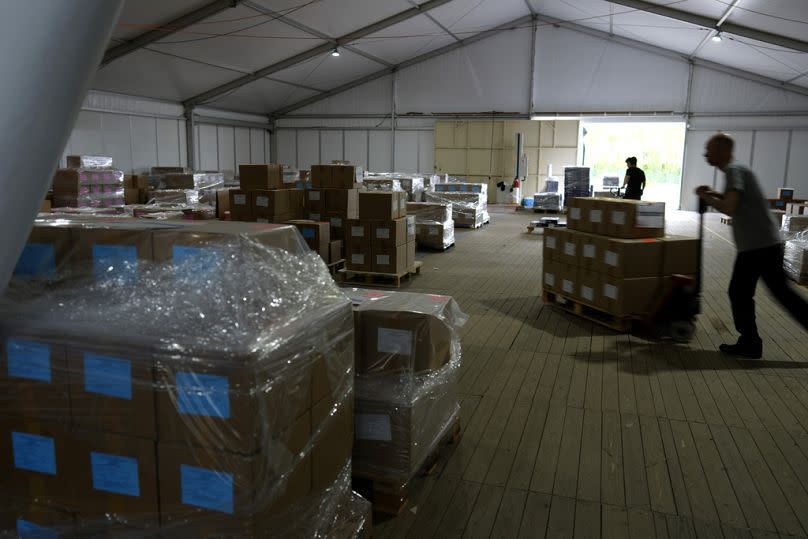 Workers push boxes full of voting ballots and election materials as they are prepared to be shipped to polling stations at the Inni Group in Kortrijk, Belgium on Wednesday