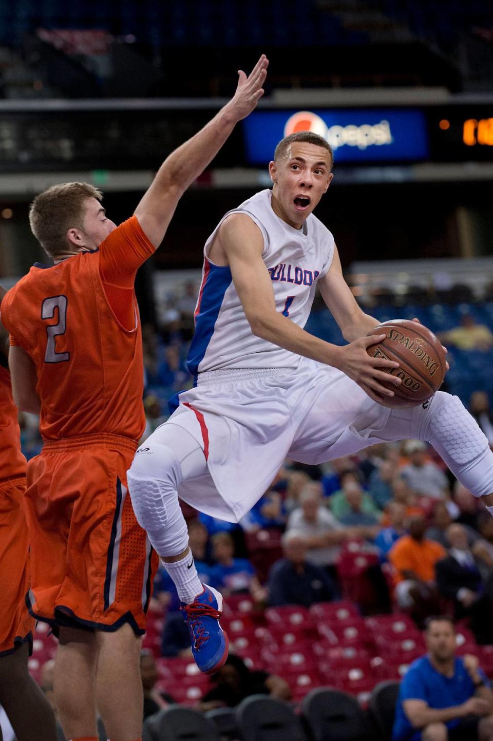 In the 2014 high school boys NorCal Division II championship game, Folsom’s Jordan Ford (1) drives to the basket to score against Cosumnes Oaks’ Matt Muldavin (2) at Sleep Train Arena in Sacramento. Ford led all scorers in the game with 20 points. Folsom High School won 68-51.