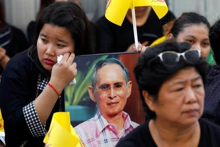 A woman holds a portrait of Thailand's late King Bhumibol Adulyadej at the Siriraj hospital in Bangkok, Thailand, October 14, 2016. REUTERS/Chaiwat Subprasom