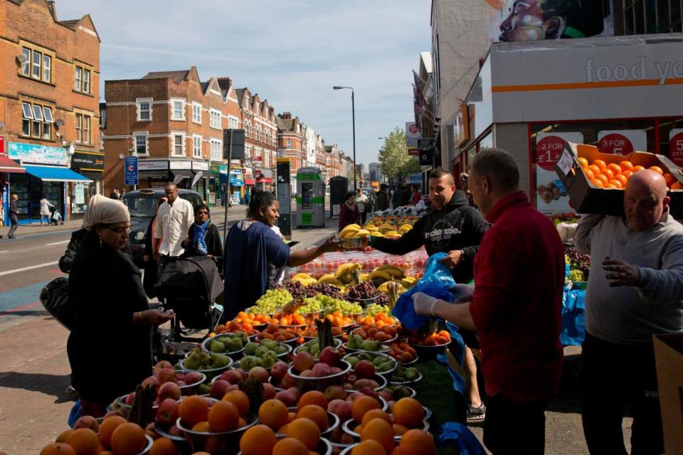 Cool neighbourhood: Residents by fruit at a market in Tooting (AFP/Getty Images)