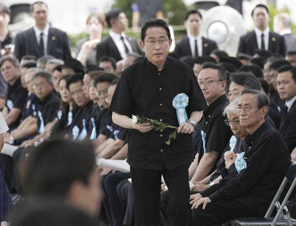 Japan's Prime Minister Fumio Kishida prepares to offer a flower during a memorial ceremony for all war dead in Okinawa at the Peace Memorial Park in Itoman, Okinawa prefecture, southern Japan Friday, June 23, 2023. Japan marked the Battle of Okinawa, one of the bloodiest battles of World War II fought on the southern Japanese island, which ended 78 years ago. (Kyodo News via AP)