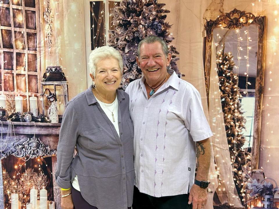 photo of Bill and Carol Plaut in front of holiday decorations