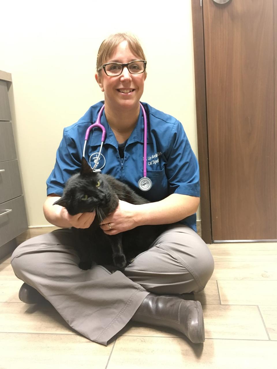 Dr. Liz Ruelle is a veterinarian at Wild Rose Cat Clinic in Calgary. She poses here with her patient Shadow. 