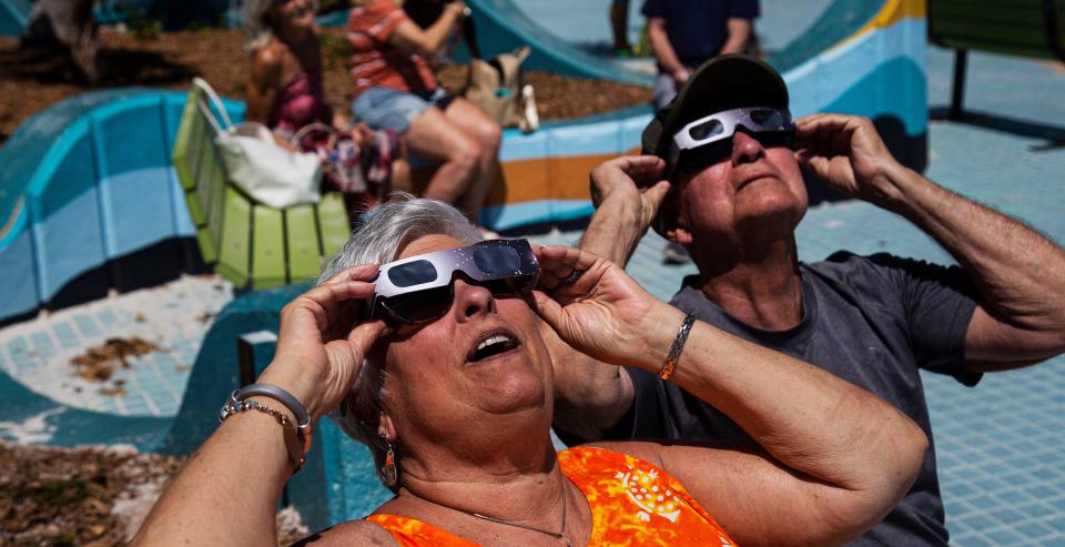 Karen and Ron McKissock view the solar eclipse on Fort Myers Beach on Monday, April 8, 2024. Fort Myers Beach got a 52% view of the eclipse.