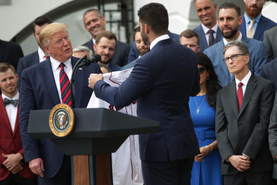 U.S. President Donald Trump is presented with a jersey by right fielder J.D. Martinez as principal owner John W. Henry look on during a South Lawn event to honor the Boston Red Sox at the White House May 9, 2019 in Washington, DC. President Donald Trump hosted the Boston Red Sox to honor their championship of the 2018 World Series.(Photo by Alex Wong/Getty Images)