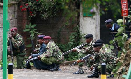 Kenyan police officers take position during the ongoing military operation at the Westgate Shopping Centre in the capital Nairobi, September 23, 2013. Gunfire and explosions sounded on Monday from the Nairobi mall where militants from Somalia's al Qaeda-linked al Shabaab group threatened to kill hostages on the third day of a raid in which at least 68 have already died. REUTERS/Thomas Mukoya