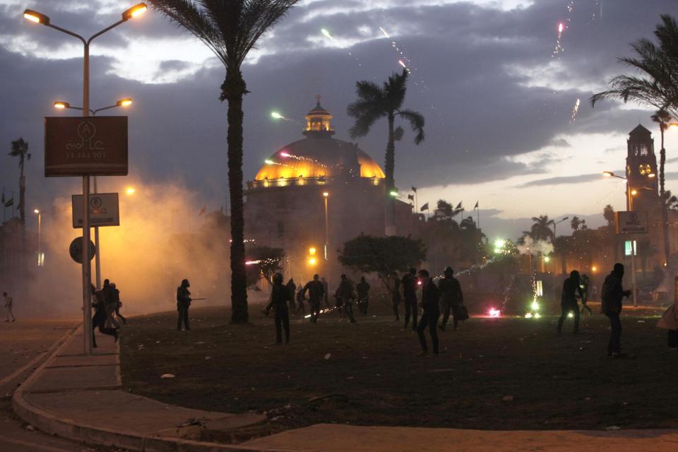 Cairo University students, supporters of the Muslim Brotherhood and ousted Egyptian President Mursi, throw fireworks towards security forces during a clash in Cairo