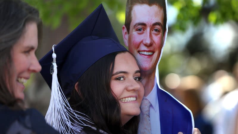 Kaitlyn Salazar hugs a cardboard statue of her brother, Jacob Schreiner, following the BYU commencement ceremony at the Marriott Center in Provo on Thursday, April 25, 2024. Salazar was awarded a Bachelor of Communications degree. Schreiner was unable to attend the graduation due to his current mission service at the Adriatic North Mission in Bosnia.