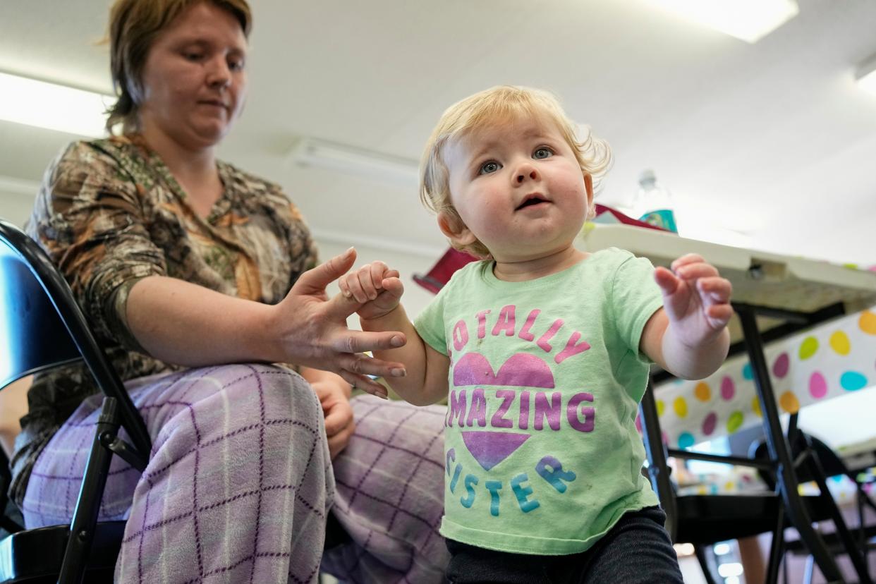 Savannah Gilliland, 27, of Albany, Ohio, holds on to her 11-month-old daughter, Sarah, during the monthly gathering of the Vinton County Health Department’s Help Me Grow program in Hamden, Ohio on April 13, 2023.