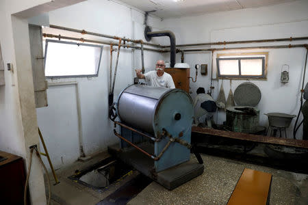 A man stands next to an industrial washing machine which hides one of the entrances to the Ayalon Institute, a factory for the production of 9mm bullets for the Sten submachine gun that was secretly built in 1945 by Jewish paramilitary group Hahagana during the British Mandate, in Rehovot, Israel, June 14, 2018. Picture taken June 14, 2018. REUTERS/Ronen Zvulun