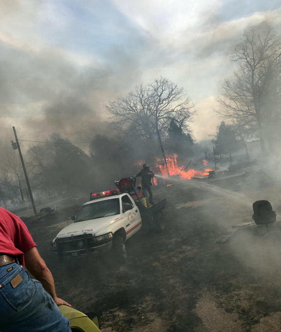 In this Jan. 11, 2017, photo provided by Sherman Hiatt, people work to put out a wildfire triggered when a pile of chicken manure caught fire in a barn as it threatens property near Charleston, Ark. Agriculture experts are warning farmers to make sure their waste piles don't grow too high because the can catch fire through spontaneous combustion. (AP Photo/Sherman Hiatt)