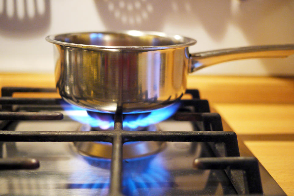 Blue methane flames reflecting, detail of kitchen. The cost of investment in Britain's green energy sector could be higher than previously forecast due to higher interest rates.