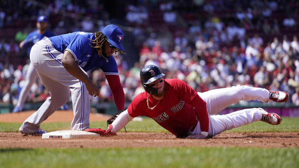 Boston Red Sox's Alex Verdugo, right, dives back safely, beating the tag by Toronto Blue Jays first baseman Vladimir Guerrero Jr., on a pick-off attempt in the second inning of a baseball game at Fenway Park, Wednesday, July 28, 2021, in Boston. (AP Photo/Charles Krupa)