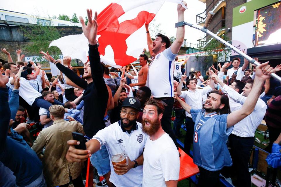 England fans in London's Flat Iron Square celebrate during the team's first match of the World Cup (REUTERS)