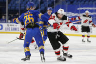 Buffalo Sabres defenseman Rasmus Dahlin (26) and New Jersey Devils forward Miles Wood (44) collide during the first period of an NHL hockey game Saturday, Jan. 30, 2021, in Buffalo, N.Y. (AP Photo/Jeffrey T. Barnes)