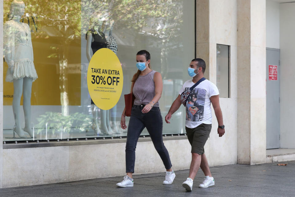 A couple is seen wearing masks while walking down Hay Street mall in Perth, Australia. 